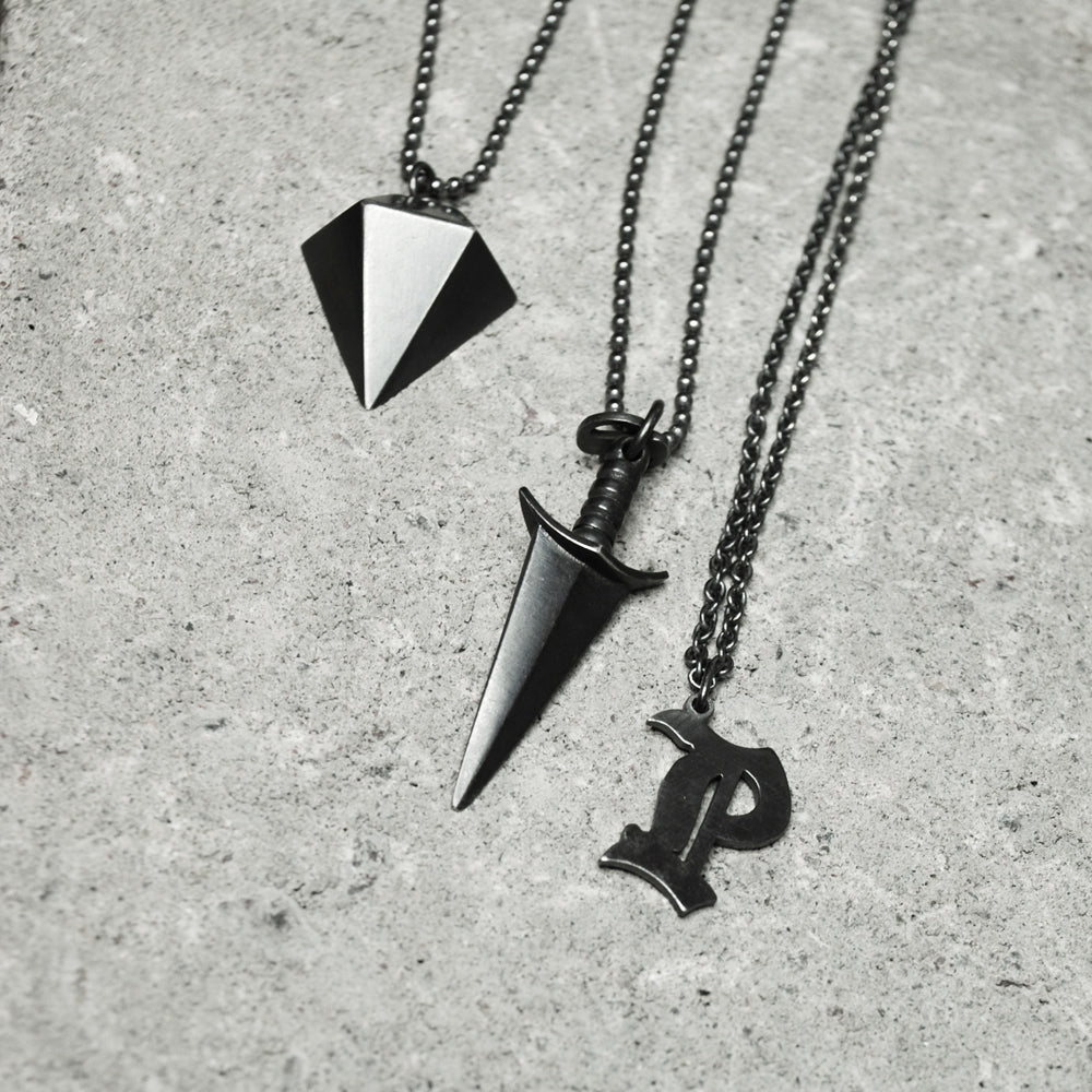 https://wildandarrow.com/cdn/shop/products/kajsa-aman_gothic_initial_letter_pendant_diamond_dagger_necklaces_sterling_silver_black_handmade_by_master_goldsmith_stockholm_wild-and-arrow_jewelry_sweden_store_lowres.jpg?v=1553173069